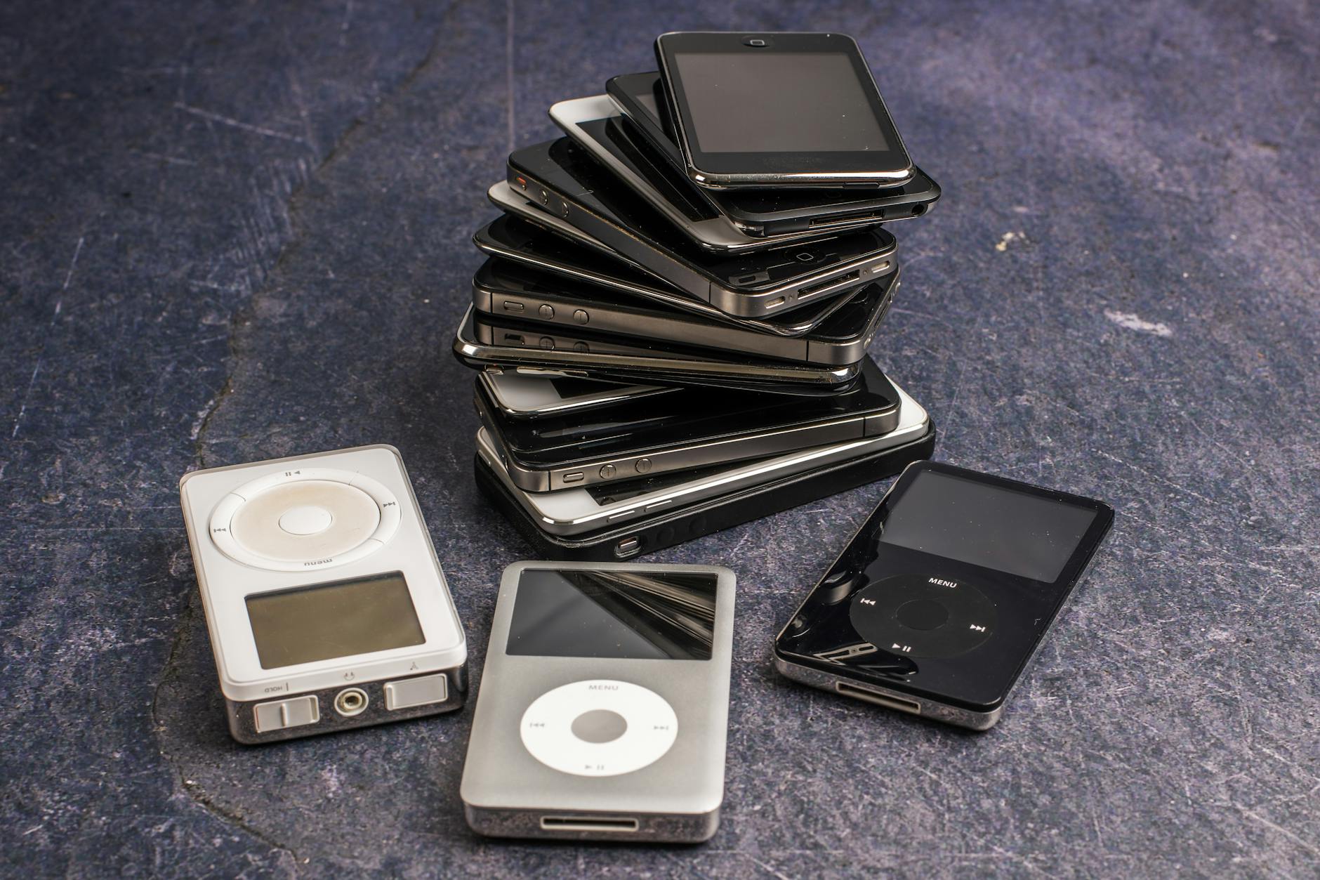 various music players and pile of aged smartphones